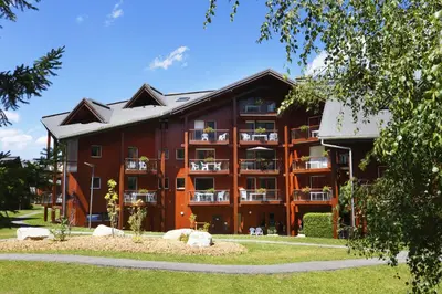 a large red building with balconies at Résidence Goélia Le Nevez in Les Contamines-Montjoie