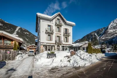 a large white building with flowers on the windows at Eden Hotel, Apartments and Chalet Chamonix Les Praz in Chamonix-Mont-Blanc