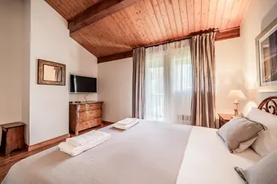 a bedroom with a large white bed and a window at Eden Hotel, Apartments and Chalet Chamonix Les Praz in Chamonix-Mont-Blanc
