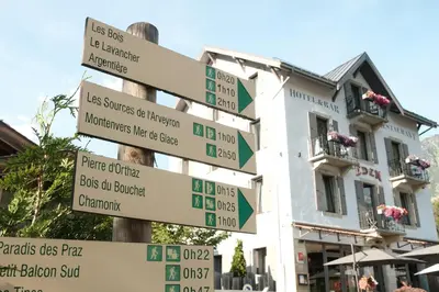 a pole with street signs in front of a building at Eden Hotel, Apartments and Chalet Chamonix Les Praz in Chamonix-Mont-Blanc