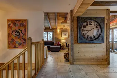 a living room with a large clock on the wall at Chalet Capricorne in Chamonix-Mont-Blanc