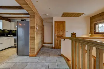 a kitchen with a stainless steel refrigerator and wooden walls at Chalet Capricorne in Chamonix-Mont-Blanc
