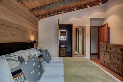 a bedroom with a bed and a wooden wall at Chalet Capricorne in Chamonix-Mont-Blanc