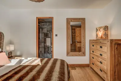 a bedroom with a bed and a dresser and a mirror at Chalet Capricorne in Chamonix-Mont-Blanc