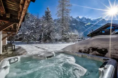 a jacuzzi tub in the snow with mountains at Chalet Capricorne in Chamonix-Mont-Blanc