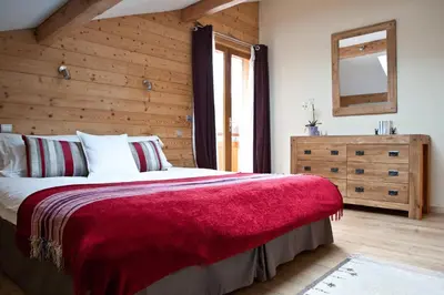 a bedroom with a large bed with a red blanket at Chalet Les Favrands in Chamonix-Mont-Blanc
