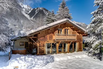 a log cabin in the snow with snow covered trees at Chalet Les Favrands in Chamonix-Mont-Blanc