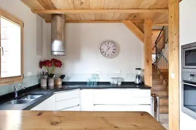 a kitchen with a sink and a clock on the wall at Chalet Amelie in Chamonix-Mont-Blanc