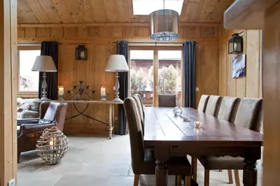 a dining room with a wooden table and chairs at Chalet Amelie in Chamonix-Mont-Blanc