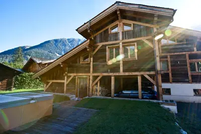 a large wooden house with a lawn in front of it at Chalet Amelie in Chamonix-Mont-Blanc