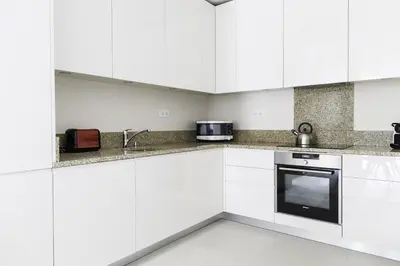 a white kitchen with a sink and a microwave at Résidence Les Chamois in Chamonix-Mont-Blanc
