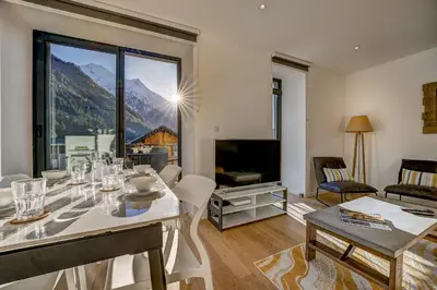 a living room with a table and a large window at Résidence Les Chamois in Chamonix-Mont-Blanc
