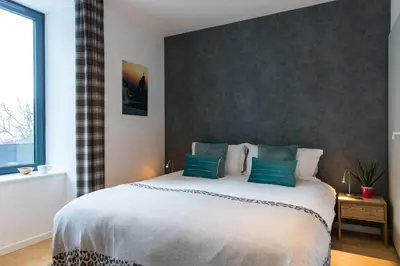 a bedroom with a large white bed with blue pillows at Résidence Les Chamois in Chamonix-Mont-Blanc