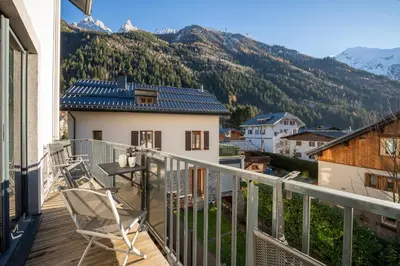 a balcony with chairs and a view of mountains at Résidence Les Chamois in Chamonix-Mont-Blanc