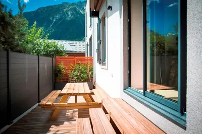 a wooden bench sitting on the side of a house at Résidence Les Chamois in Chamonix-Mont-Blanc