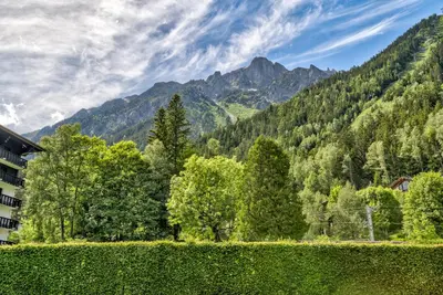 a view of a mountain range with trees and a building at Le Brevent 3 Apartment in Chamonix-Mont-Blanc