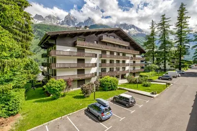 an apartment building with cars parked in a parking lot at Le Brevent 3 Apartment in Chamonix-Mont-Blanc
