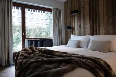 a hotel room with two beds with a blanket on them at Le Brevent 2 Apartment in Chamonix-Mont-Blanc