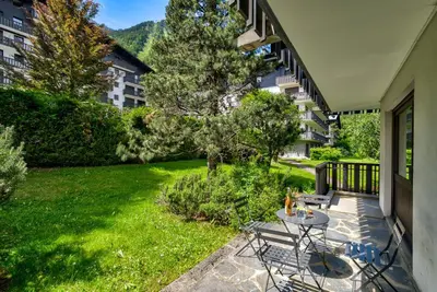 a patio with a table and chairs on a balcony at Le Brevent 2 Apartment in Chamonix-Mont-Blanc