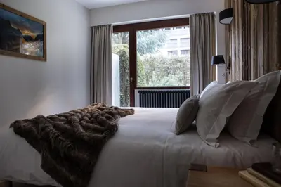 a bedroom with a large white bed with a window at Le Brevent 2 Apartment in Chamonix-Mont-Blanc