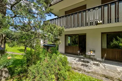 a house with a patio with a table and chairs at Le Brevent 2 Apartment in Chamonix-Mont-Blanc