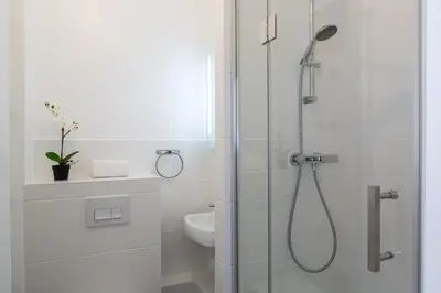 a white bathroom with a shower and a toilet at Le Brevent 2 Apartment in Chamonix-Mont-Blanc
