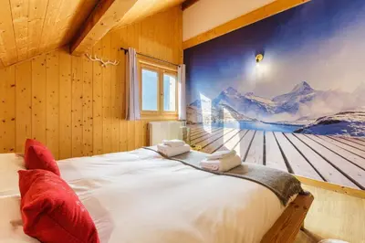 a bedroom with a large bed with a painting on the wall at MontBlanc Balcony Chamonix in Chamonix-Mont-Blanc