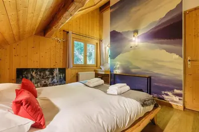 a bedroom with a bed with a painting on the wall at MontBlanc Balcony Chamonix in Chamonix-Mont-Blanc