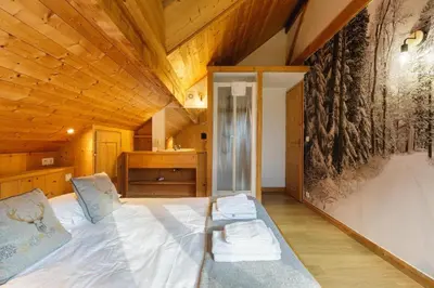 a large bed in a room with a wooden ceiling at MontBlanc Balcony Chamonix in Chamonix-Mont-Blanc