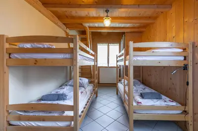 a room with three bunk beds in a cabin at Chalet Quatre Saisons in Saint-Gervais-les-Bains