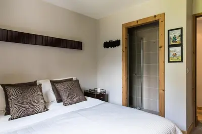a bedroom with a white bed and a glass door at Villa Floria Apartment in Chamonix-Mont-Blanc