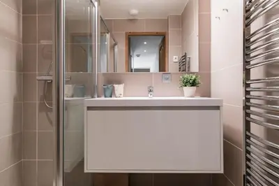 a bathroom with a white sink and a shower at Villa Floria Apartment in Chamonix-Mont-Blanc