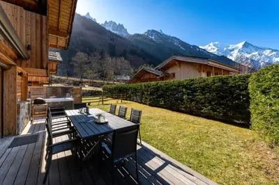 a wooden deck with a table and chairs on it at Chalet Planards 1 in Chamonix-Mont-Blanc