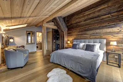 a bedroom with a bed and a wooden wall at Chalet Planards 1 in Chamonix-Mont-Blanc