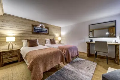 a hotel room with two beds and a mirror at Chalet Planards 1 in Chamonix-Mont-Blanc