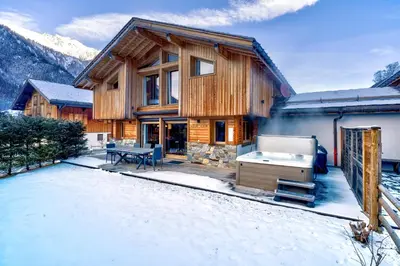a wooden house with a snow covered yard at Chalet Planards 1 in Chamonix-Mont-Blanc
