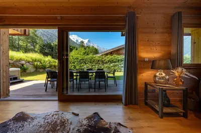 a dining room with a large glass door leading to a patio at Chalet Planards 2 in Chamonix-Mont-Blanc
