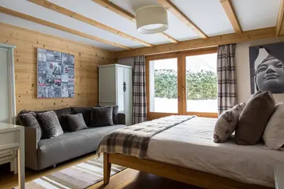 a bedroom with a bed and a couch at Chalet Le Favre in Chamonix-Mont-Blanc