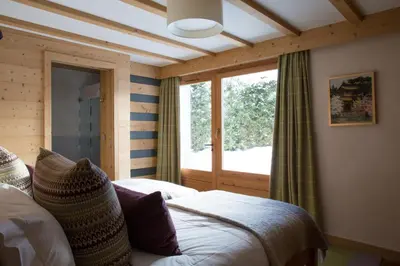 a bedroom with a bed and a large window at Chalet Le Favre in Chamonix-Mont-Blanc