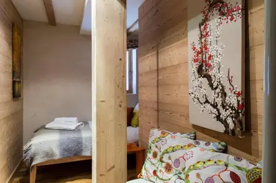 a room with a bed and a wall with wood at Chalet Le Favre in Chamonix-Mont-Blanc