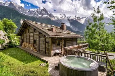 a log cabin with a hot tub on a deck at Chalet Le Favre in Chamonix-Mont-Blanc