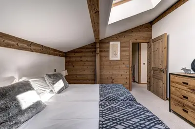 a bedroom with a bed and a wooden wall at Chalet les Sauberands in Chamonix-Mont-Blanc