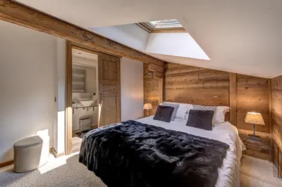 a bedroom with a large bed with wooden walls at Chalet les Sauberands in Chamonix-Mont-Blanc