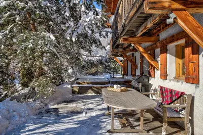 a table and chairs on the porch of a cabin at Chalet les Sauberands in Chamonix-Mont-Blanc