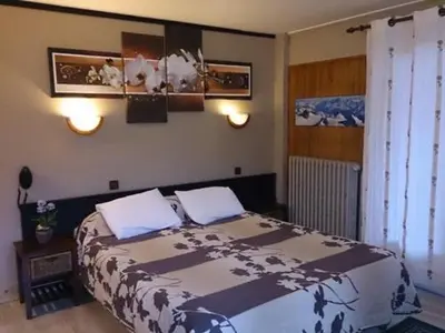 a bedroom with a large bed with two pillows at Hotel La Chaumière à 180m du télécabine et de la gare in Saint-Gervais-les-Bains