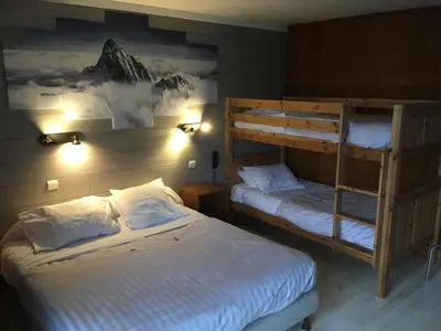 a bedroom with two bunk beds and a ladder at Hotel La Chaumière à 180m du télécabine et de la gare in Saint-Gervais-les-Bains