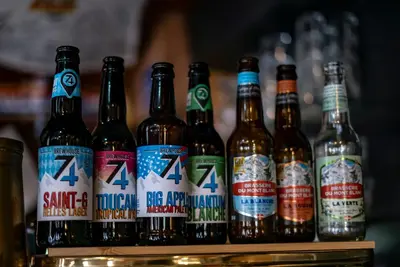 a group of beer bottles sitting on a shelf at Hotel La Chaumière à 180m du télécabine et de la gare in Saint-Gervais-les-Bains
