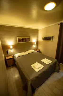 a bedroom with a large bed with two towels on it at Hotel La Chaumière à 180m du télécabine et de la gare in Saint-Gervais-les-Bains
