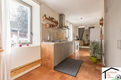 a kitchen with a large window and a kitchen counter at Le Moulin des Olirics in Sallanches
