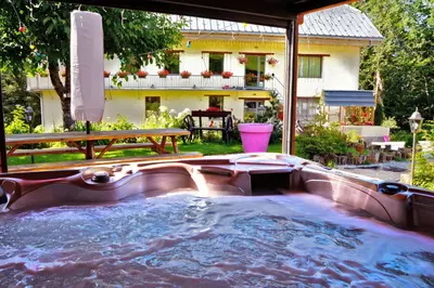 a hot tub in the backyard of a house at Le Moulin des Olirics in Sallanches